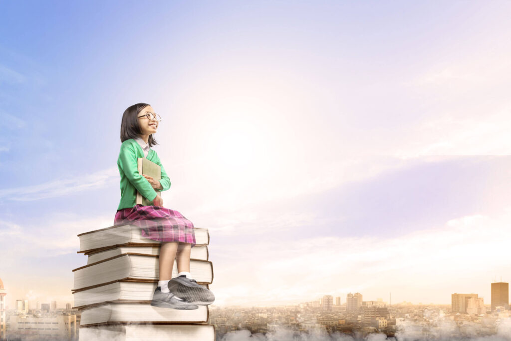 asian-cute-girl-with-glasses-holding-book-while-sitting-pile-books-with-city-blue-sky